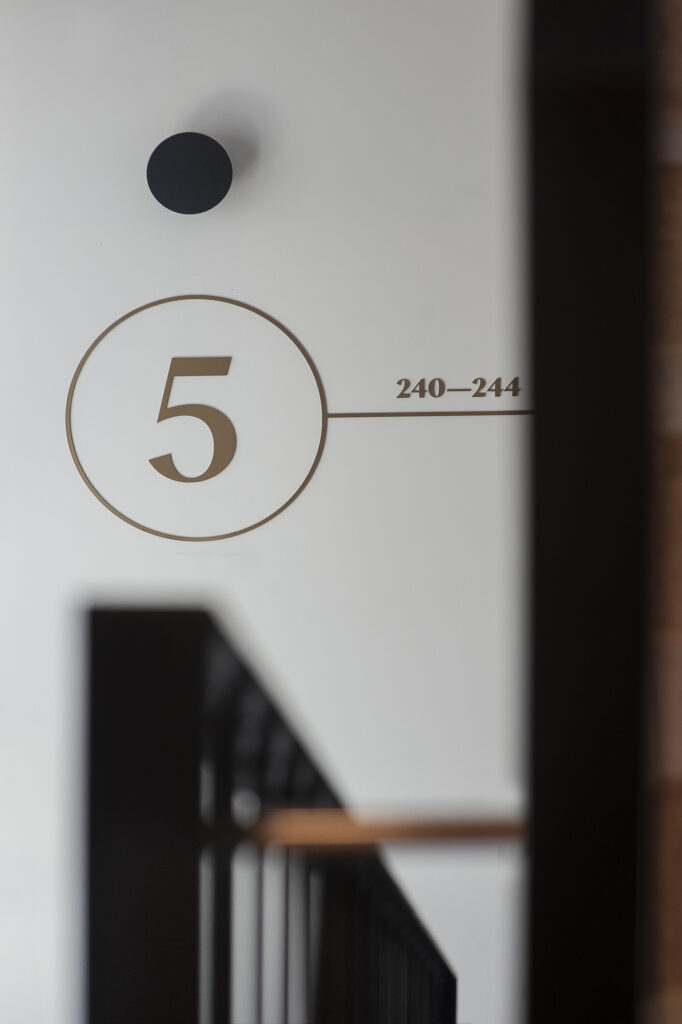 Signage floor number (wayfinding system) in staircase Doki Living in Gdansk residential building