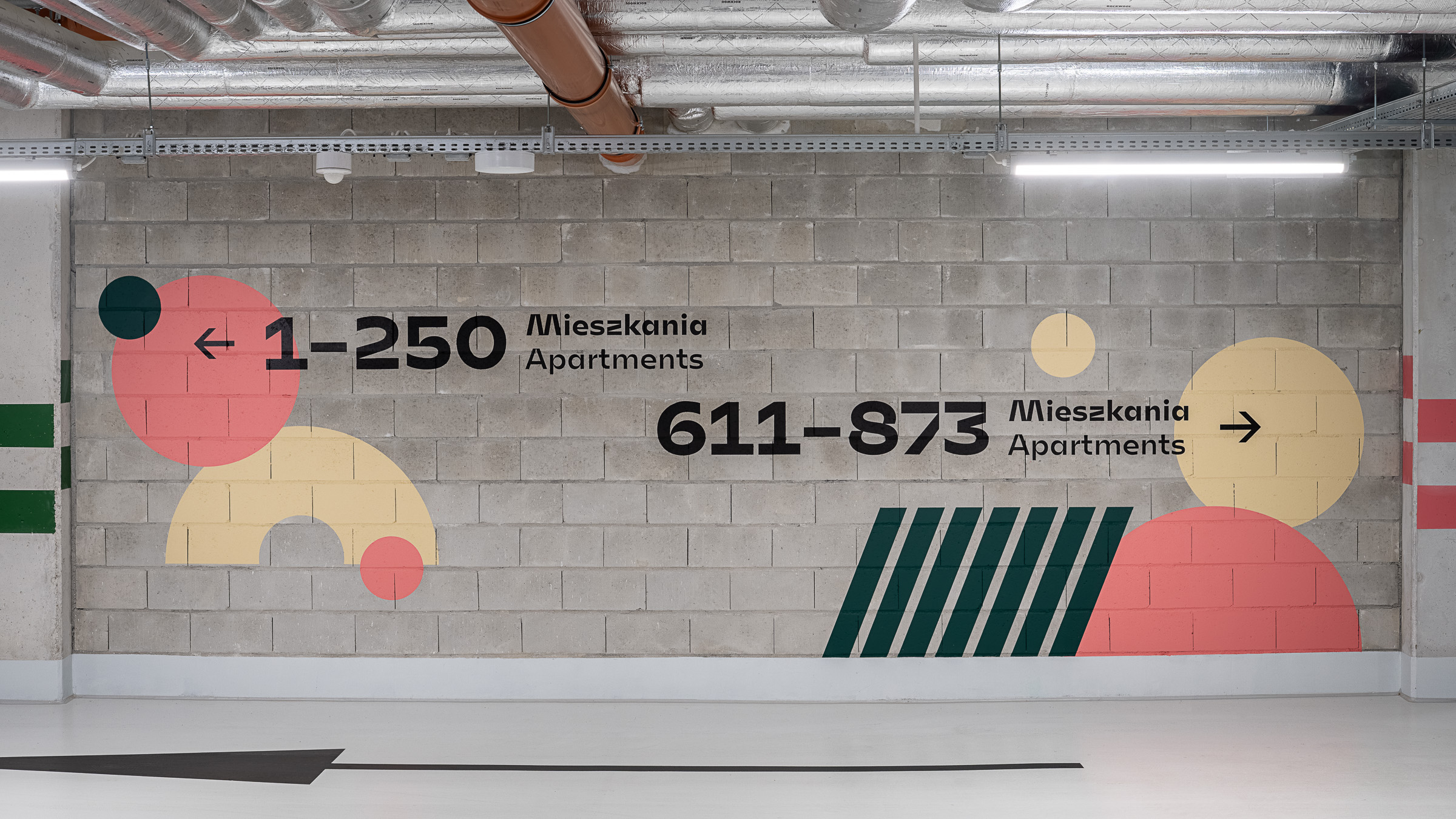 System informacji wizualnej R4R Romanowicza Kraków mural w parkingu z grafiką kierunkową