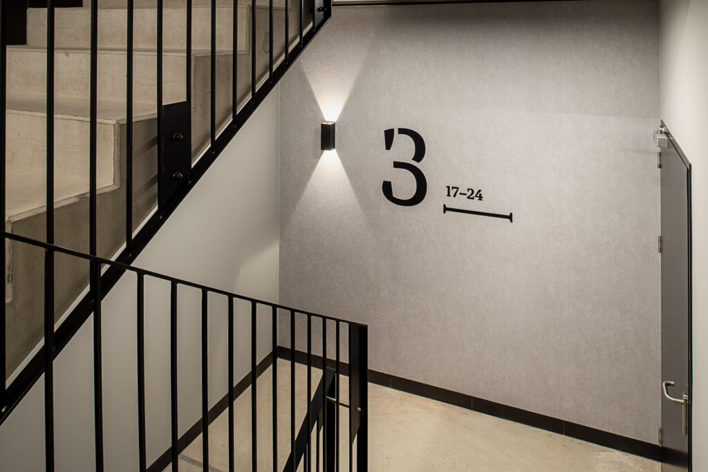 Doki Living Gdansk residential building floor number on the staircase signage