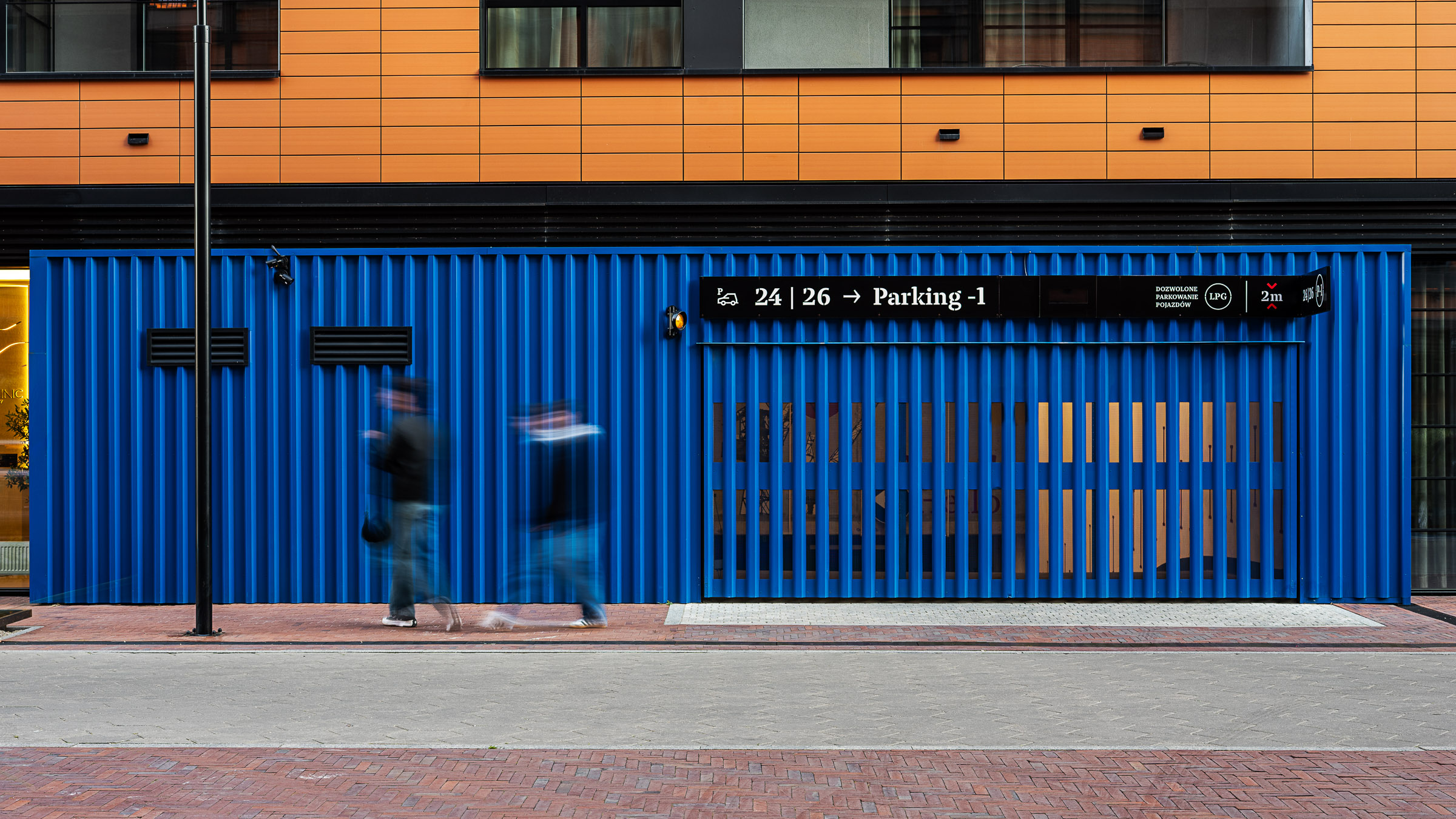 Doki Living Gdansk residential building information above the entrance to the parking